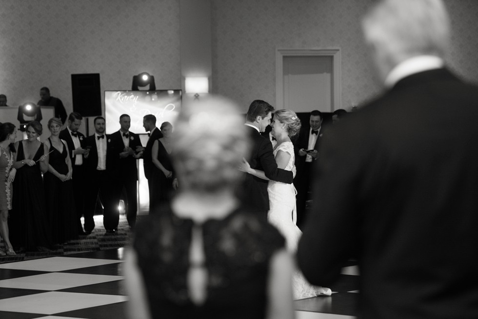 black and white looking over parents shoulder during Newly weds first dance at Baltimore Marriott Waterfront