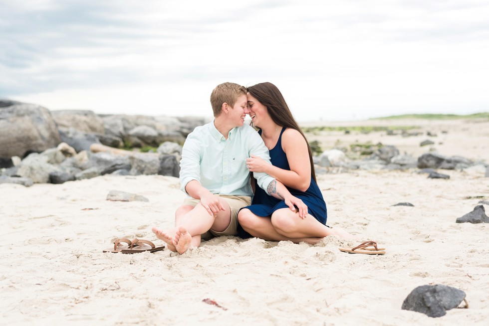 Two brides sitting in the sand on the Jersey Shore of Barnegat Lighthouse