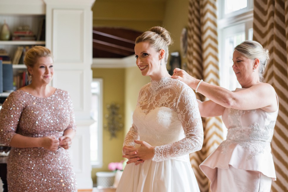 Bride getting into her WTOO by Watters strapless bridal gown with lace coverlet