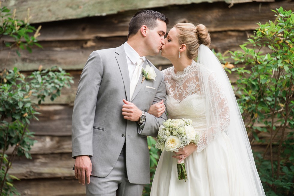 Bride and Groom kissing in front of the wood cabin at Elkridge Furance Inn