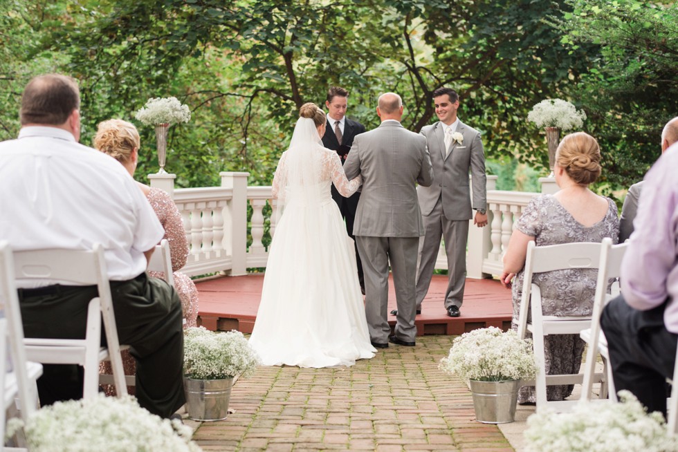 Father giving his daughter away at Elkridge Furnace Inn wedding ceremony in the garden