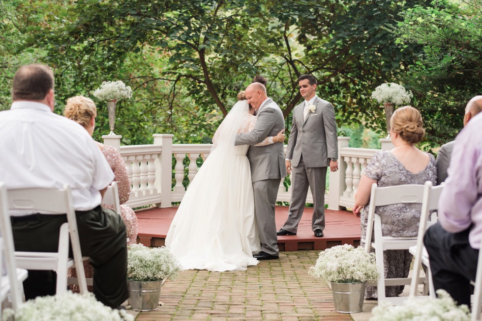 Father giving his daughter away at Elkridge Furnace Inn wedding ceremony in the garden