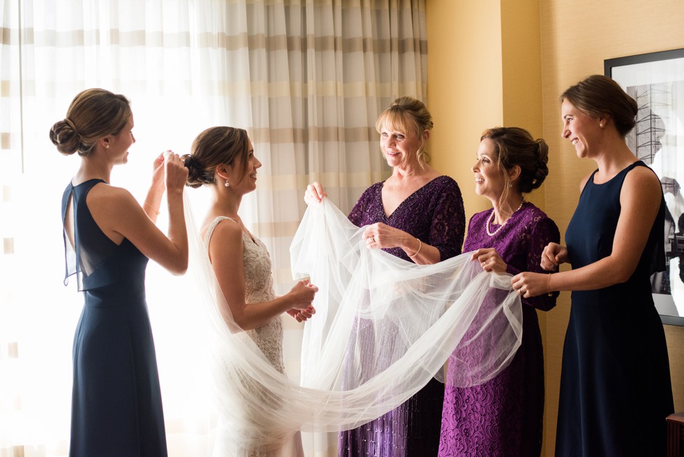 Putting the bridal veil on in her Love Couture Bridal dress with moms and sisters