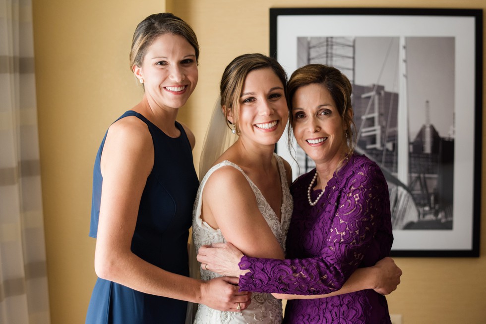 Putting the bridal veil on in her Love Couture Bridal dress with moms and sisters