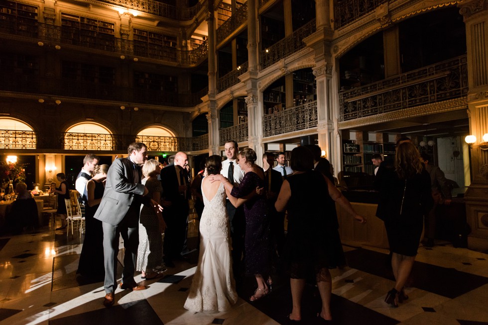 Sweet candid moments between mother of the groom and bride at a library reception