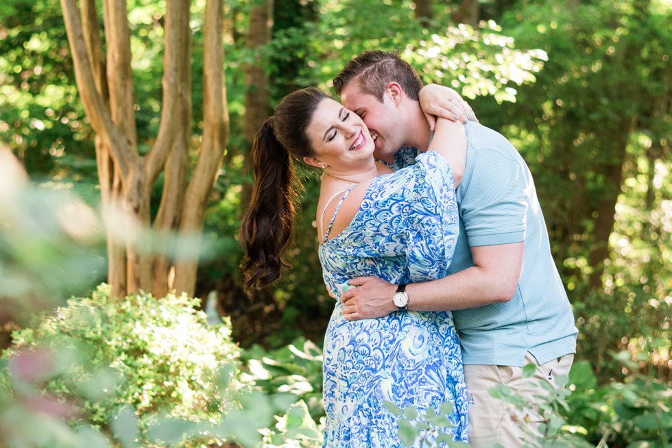 Couple in blue snuggling up in the trees in Annapolis for engagement photos