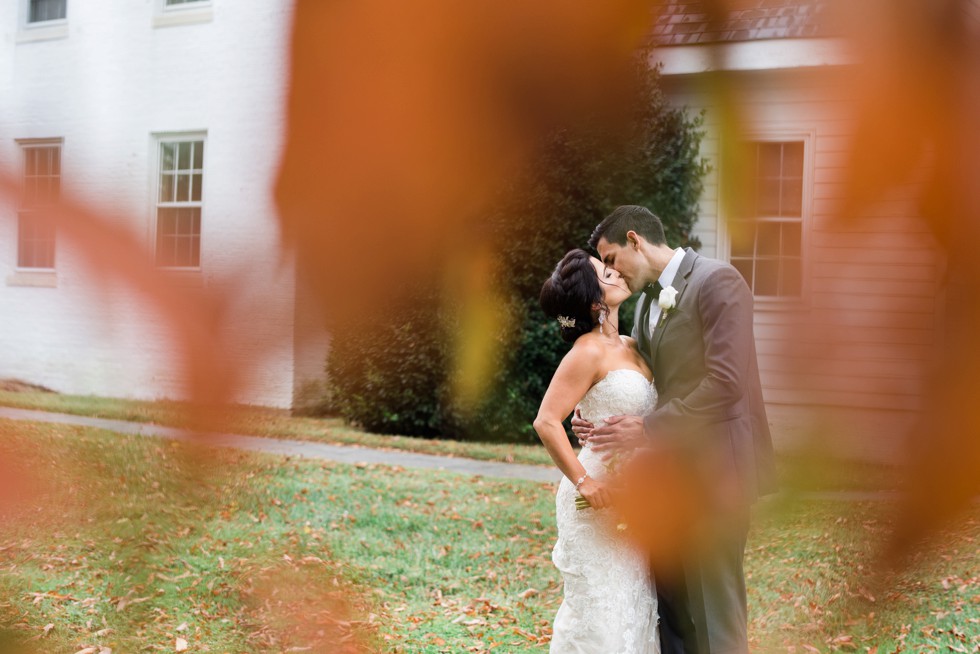 Fall orange leaves in front of bride and groom portrait