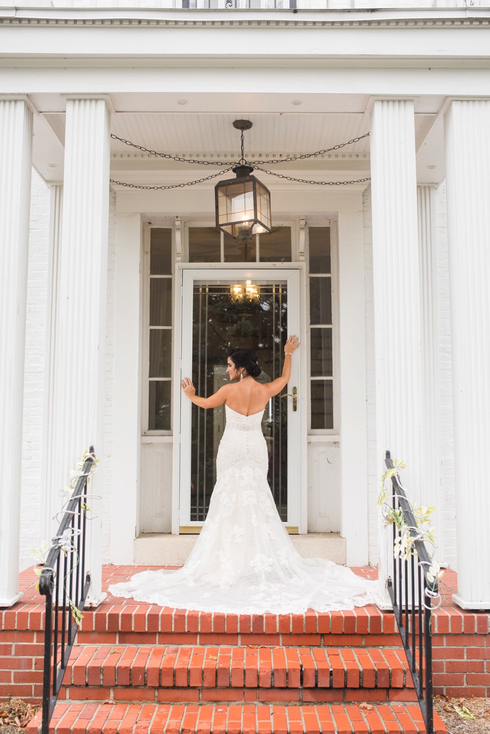 Bride and groom standing in front of a white mansion on the Eastern Shore