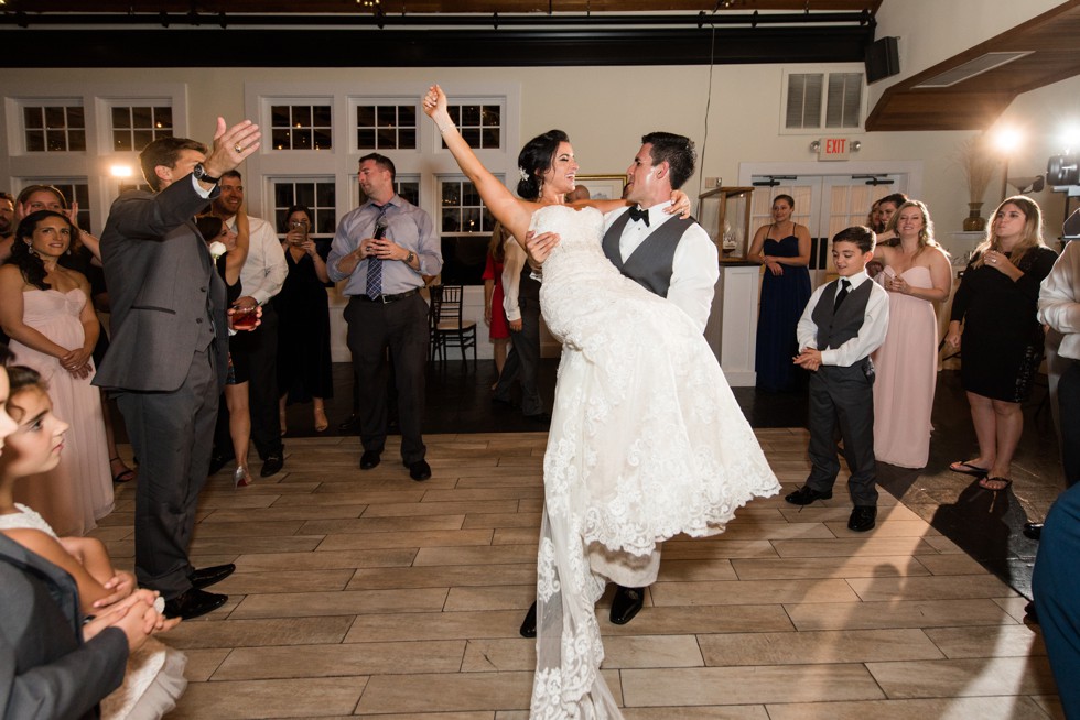 groom lifting the bride in the air at Tavern Ballroom reception