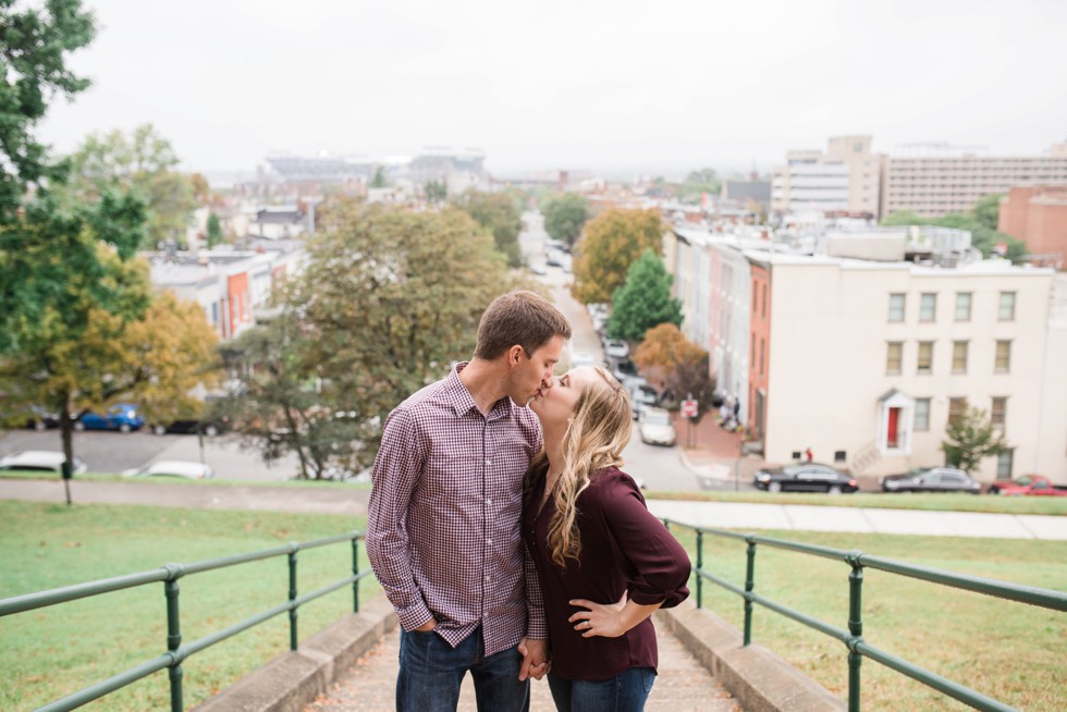 Engaged couple walking down the steps at Federal Hill overlooking Ravens stadium