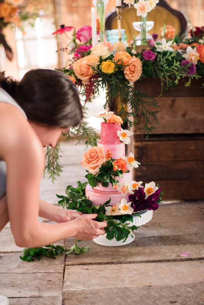 pastry chef adding flower details to wedding cake