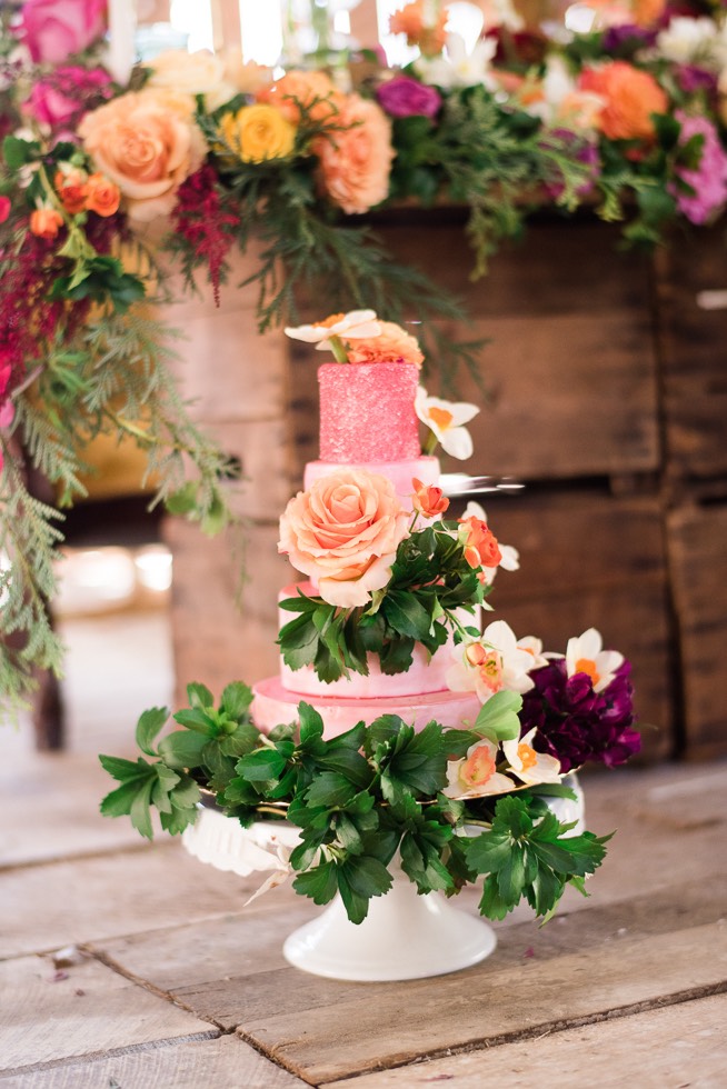 pink wedding cake with flowers and greenery