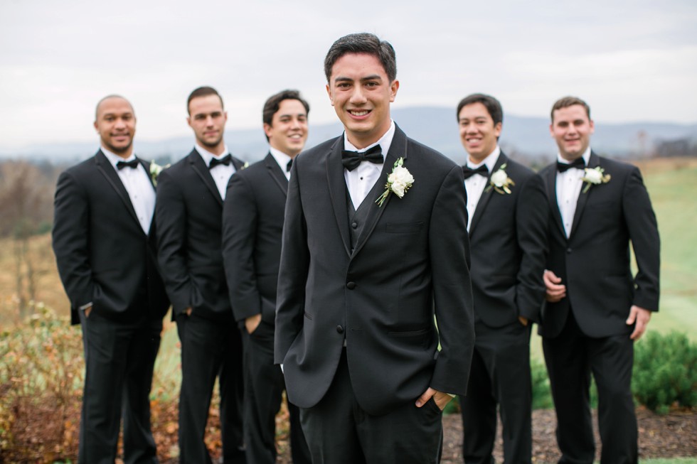 groomsmen in black tuxes on a mountain