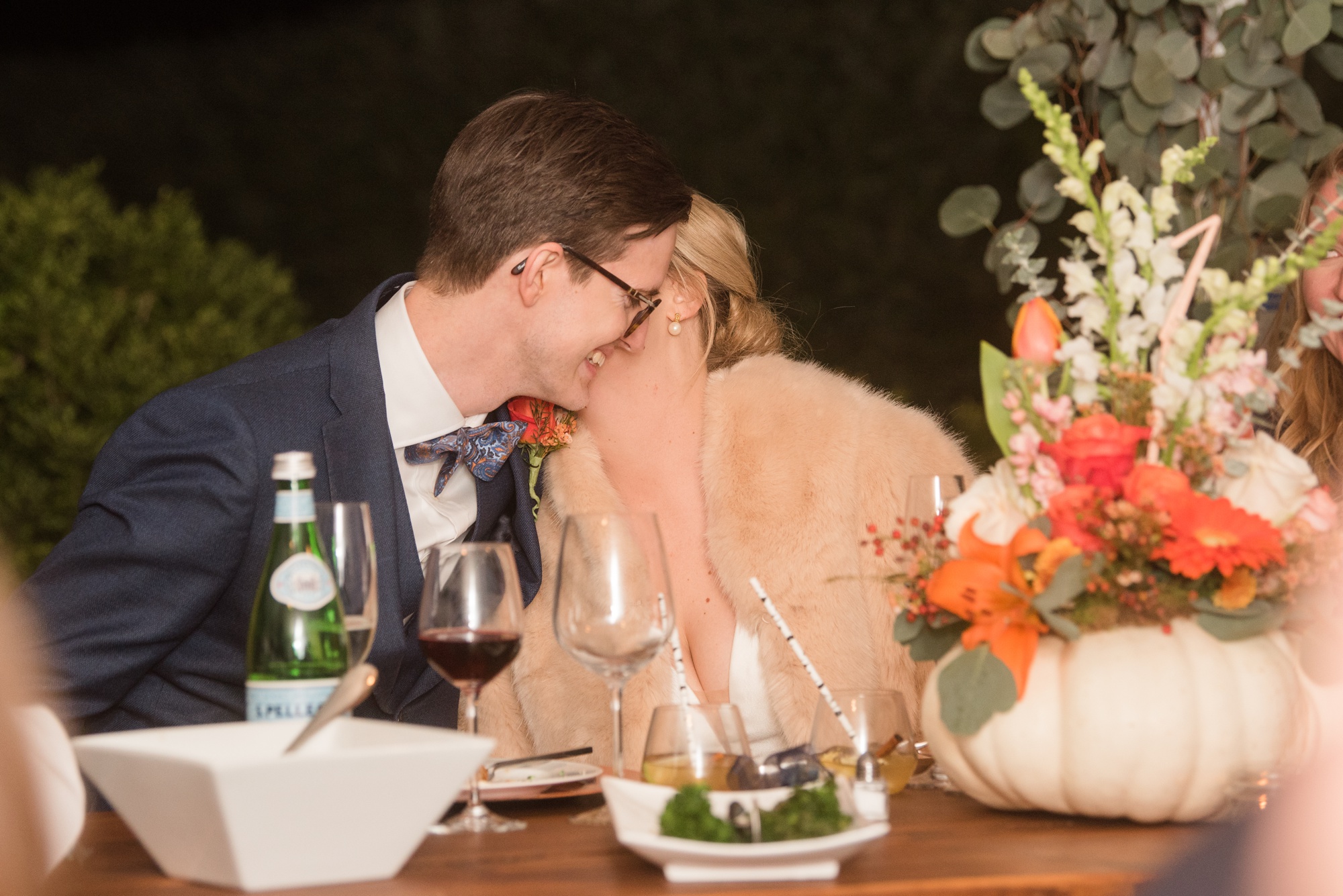 bride and groom snuggling at dinner