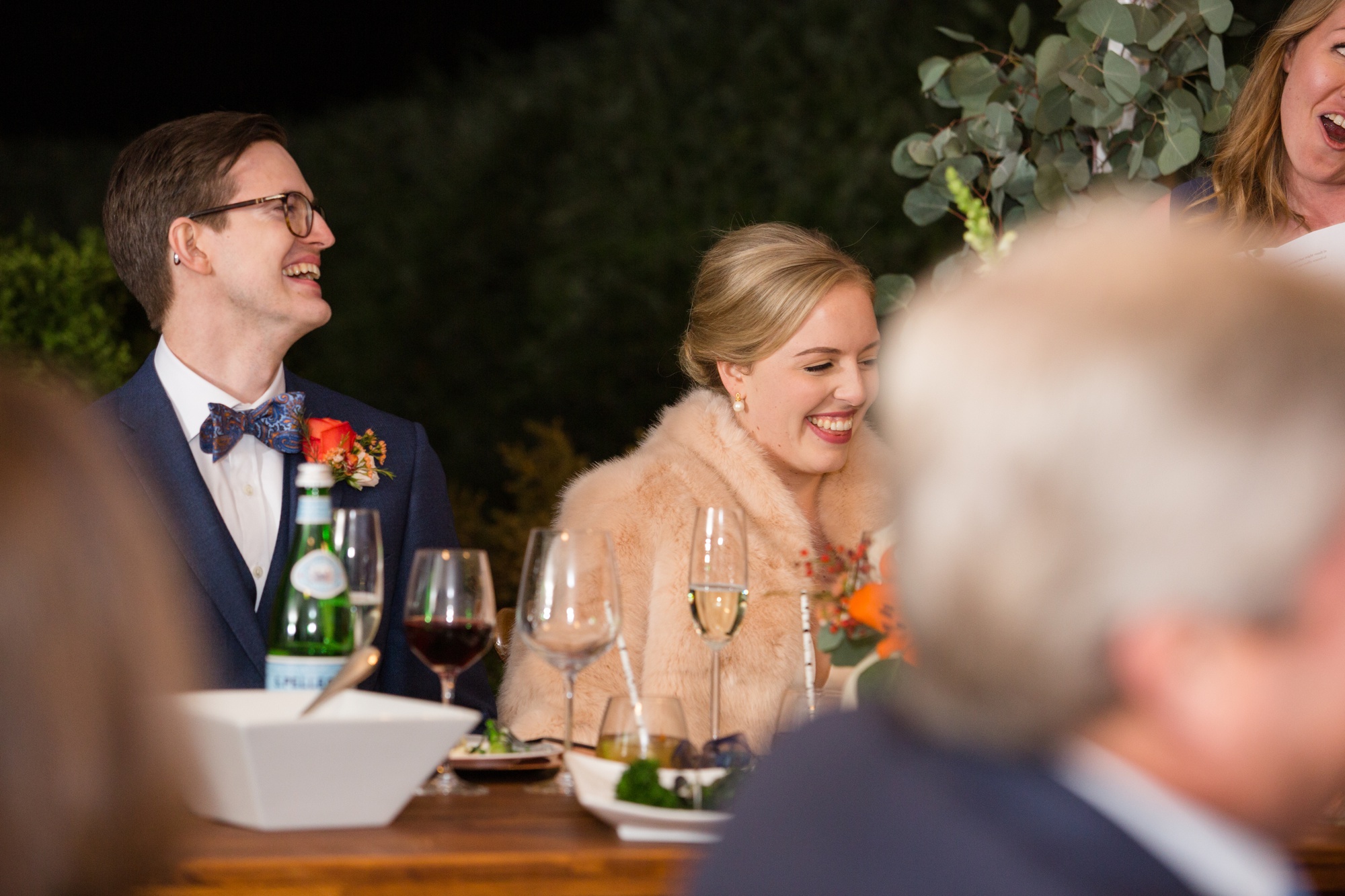 bride and groom laughing at bridesmaid toast