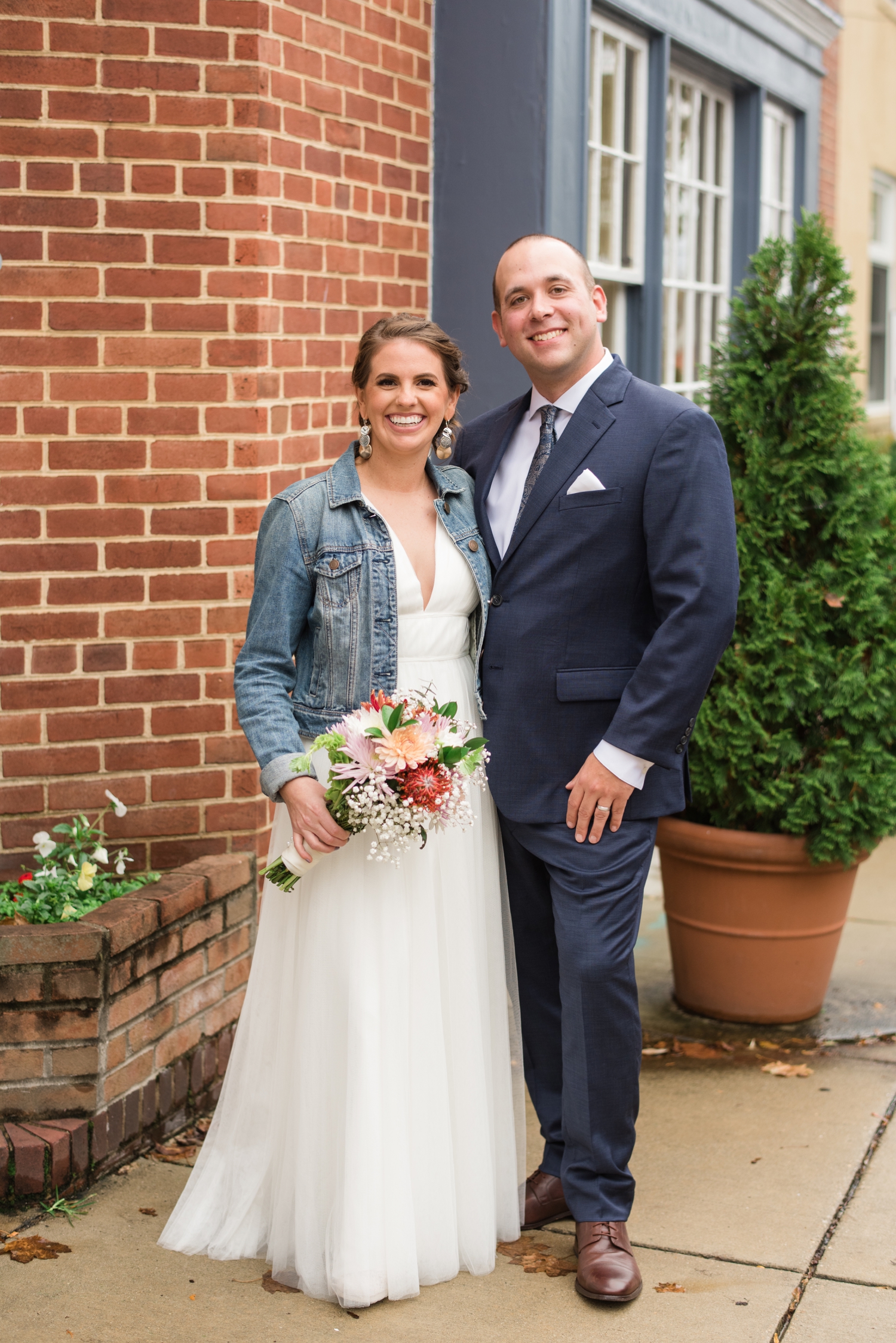 bride with jean jacket on wedding day