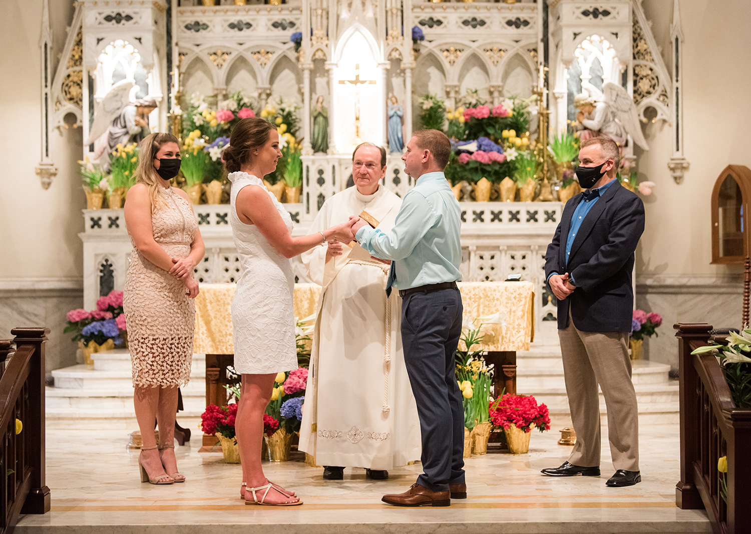 bride and groom standing in the catholic church for their wedding ceremony