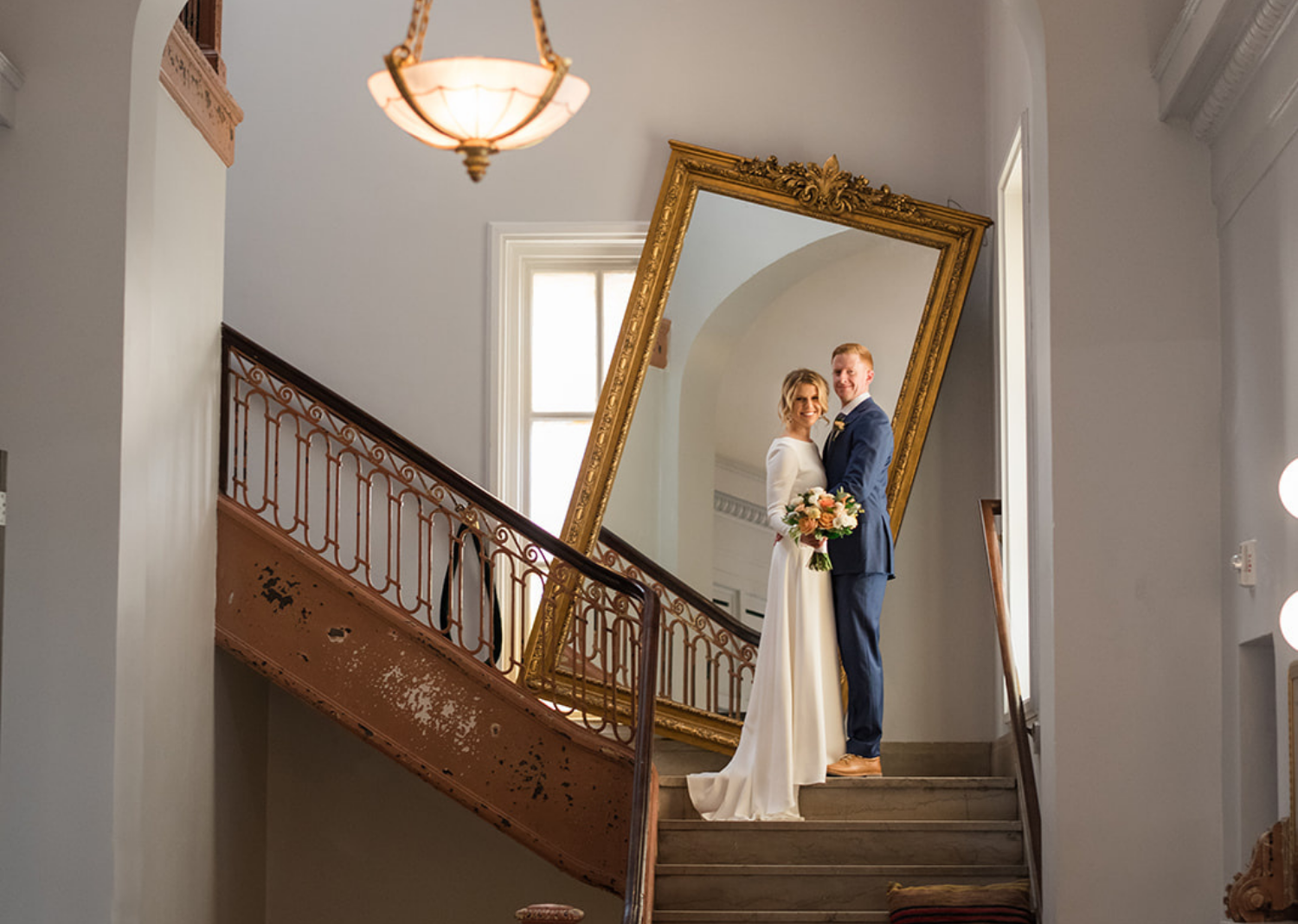 bride and groom smile in front of a gold mirror at the line hotel in washington