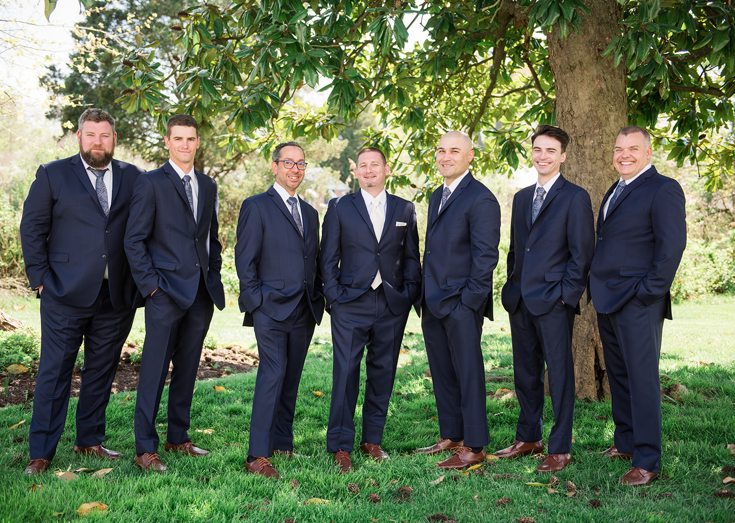 groomsmen smiling as they stand next to the groom