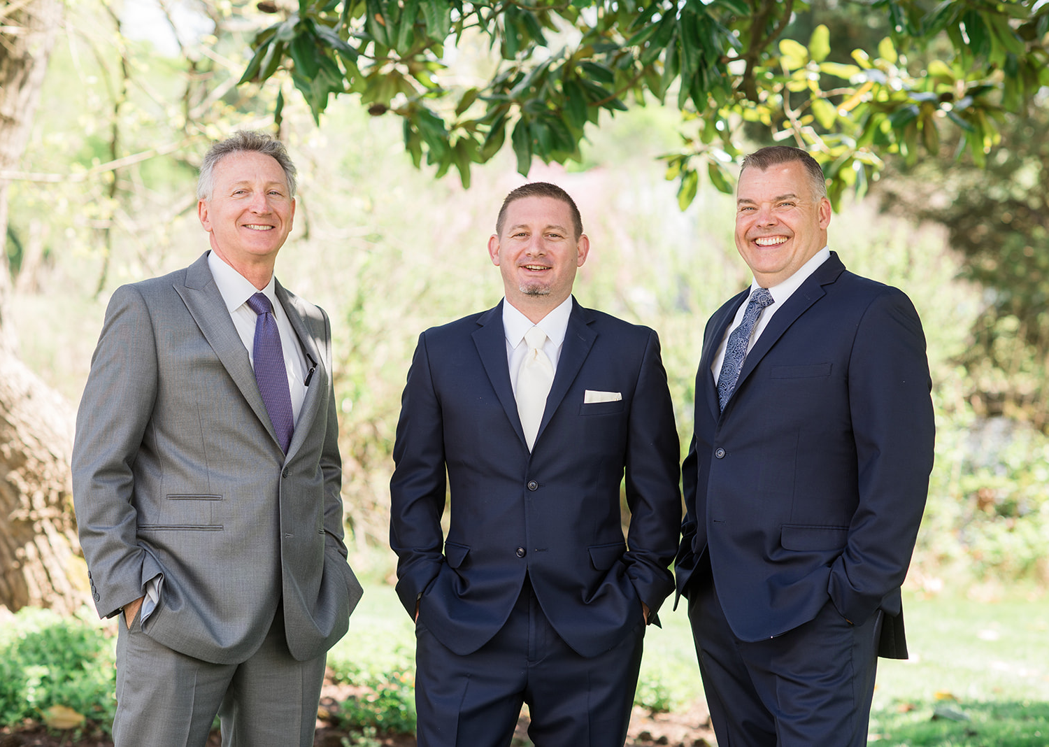 father of the groom and his brother stand next to the groom