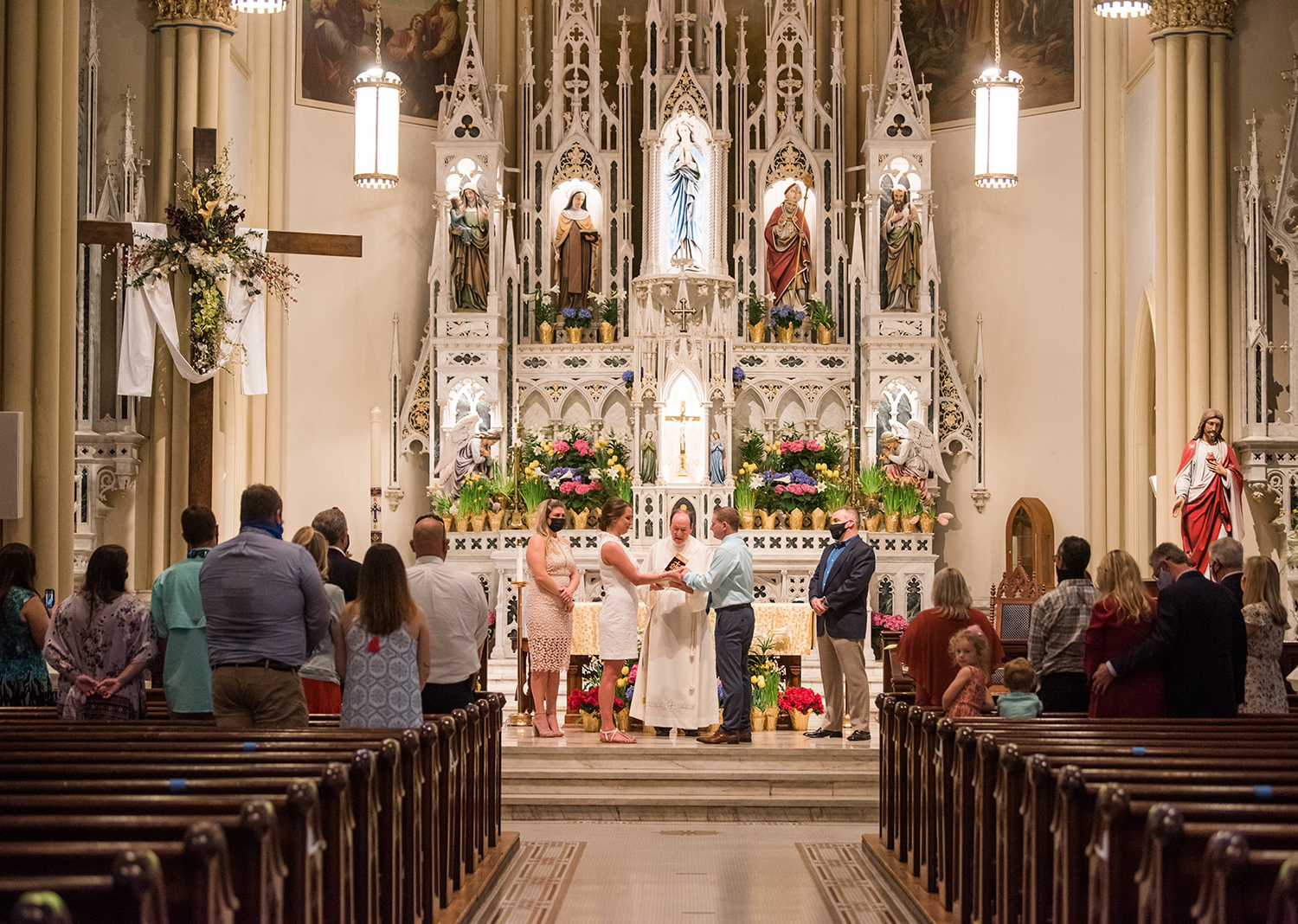 bride and groom standing in the catholic church for their wedding ceremony