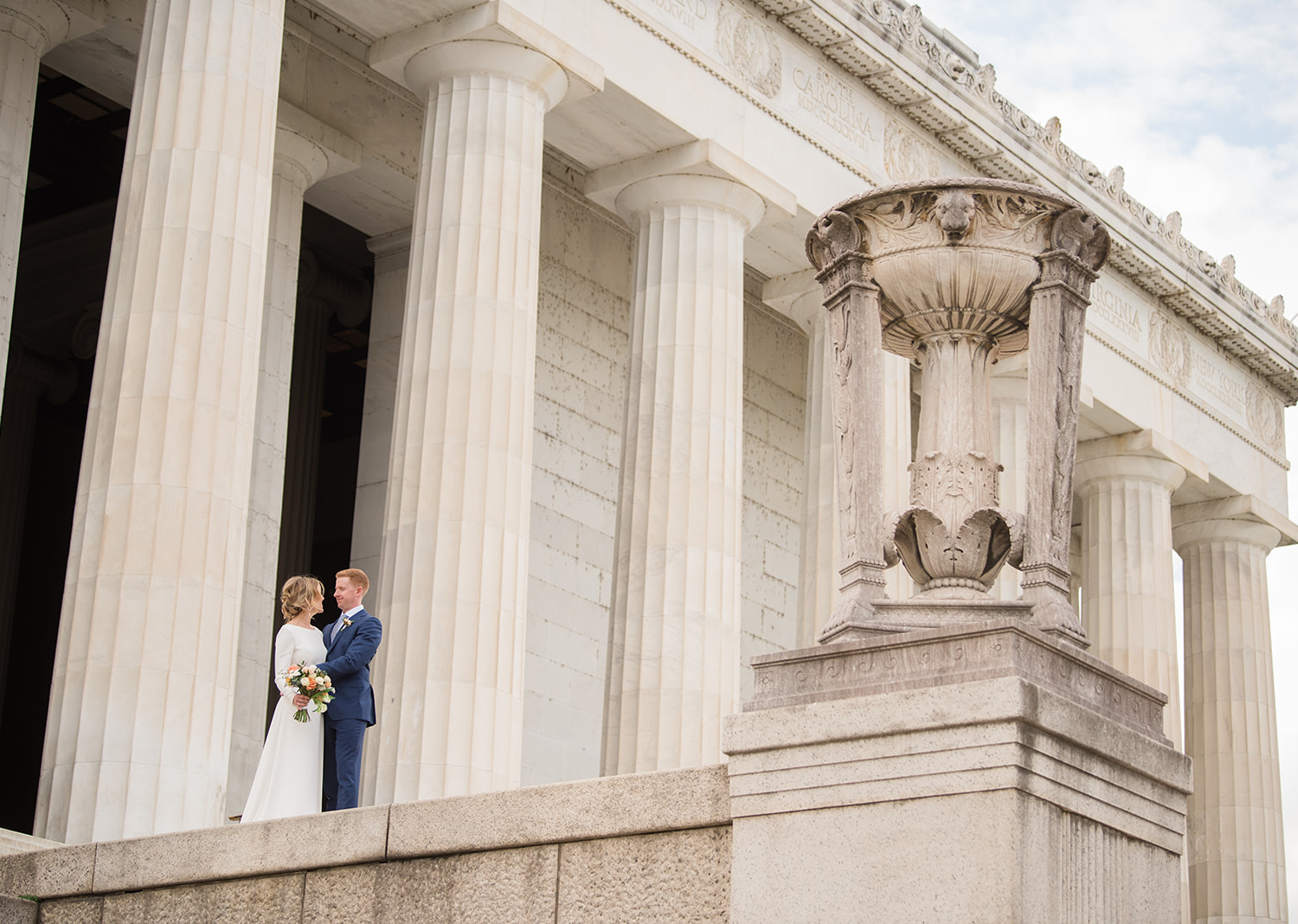 bride and groom posing in front of the lincoln memorial