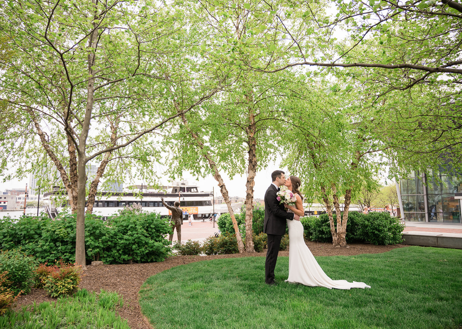 bride and groom share a kiss in a park in Baltimore