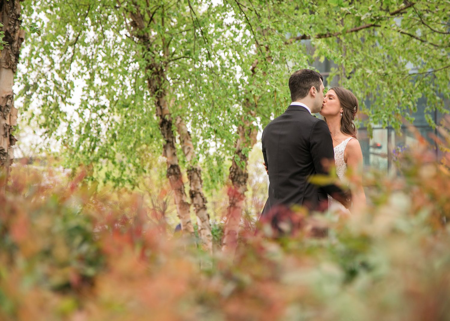 bride and groom share a kiss in a park in Baltimore