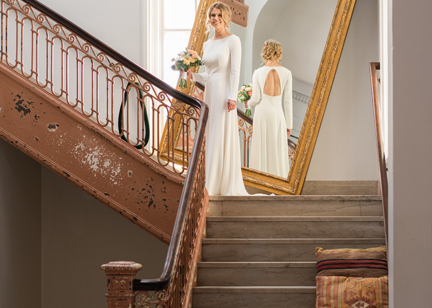 bride smiling in front of a gold mirror