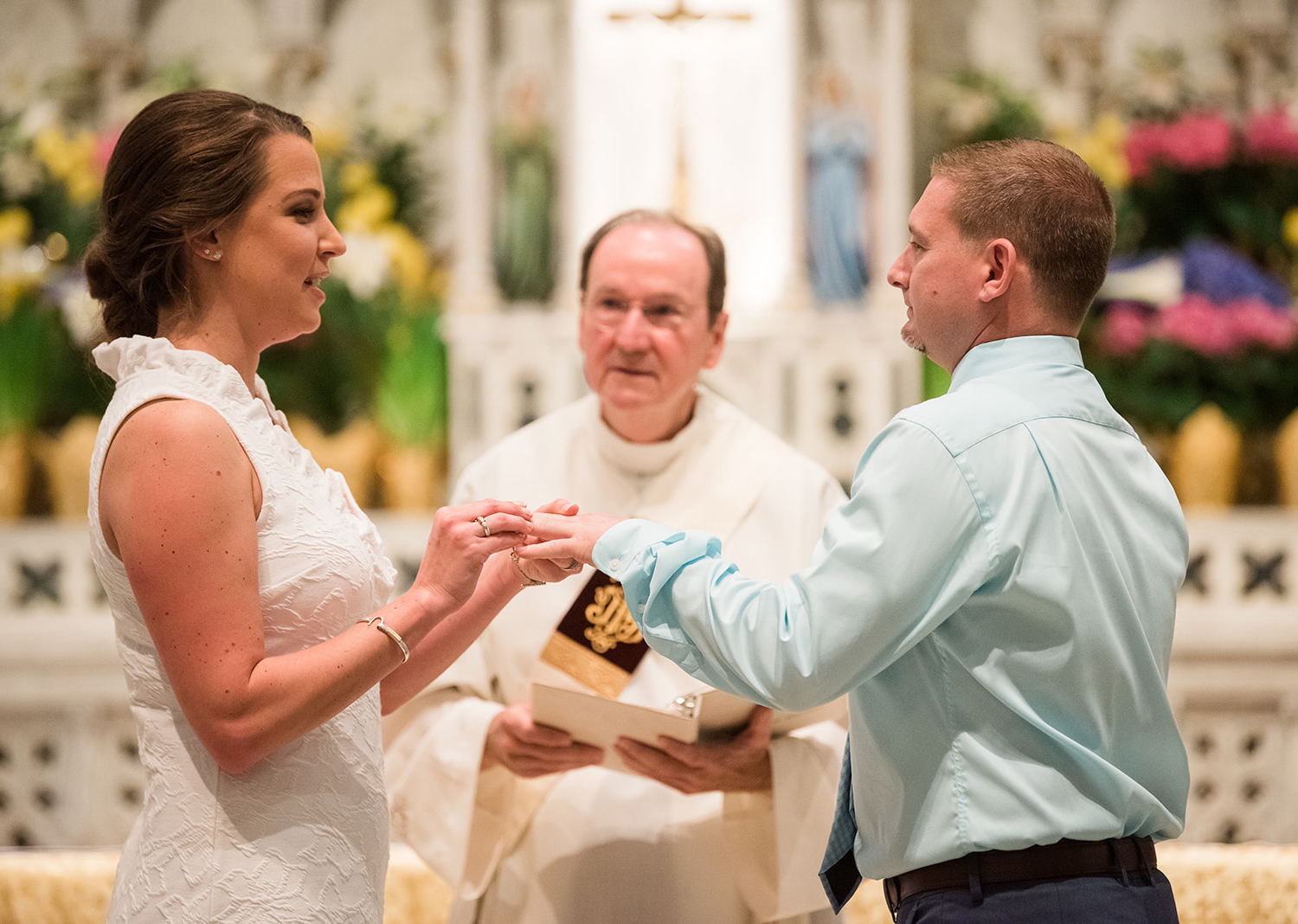 bride and groom standing in the catholic church for their wedding ceremony