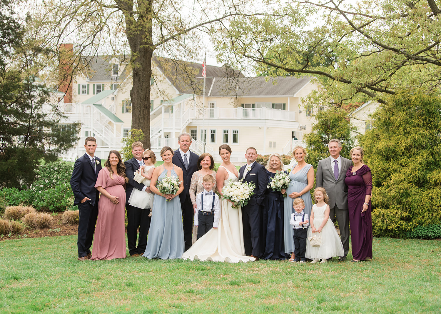 bride and groom smile surrounded by their wedding party