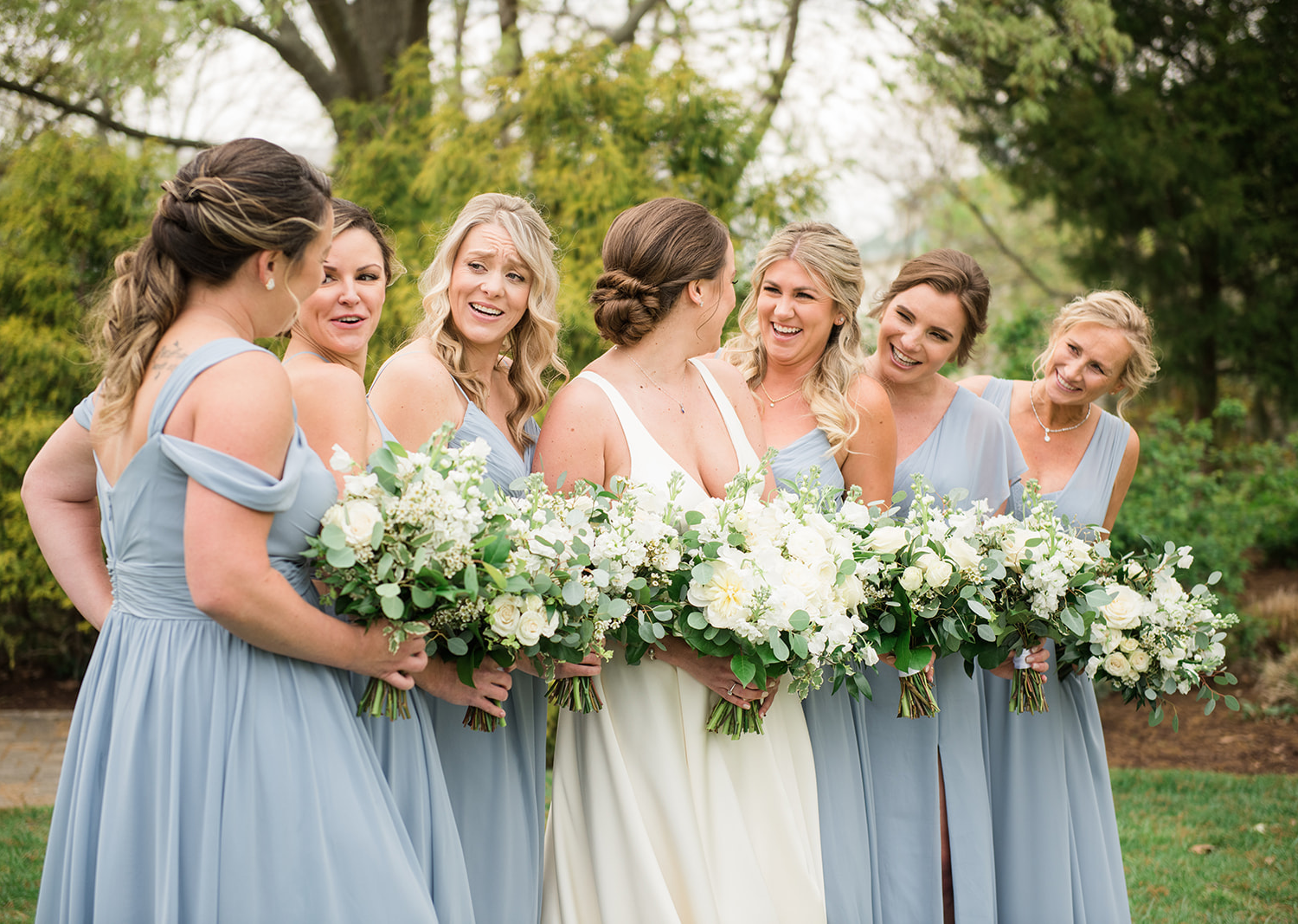 bride smiles as her bridesmaids gather around her