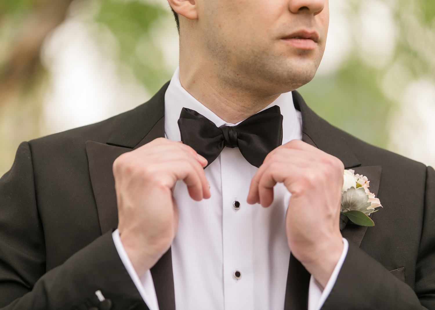 groom fixing his bow tie