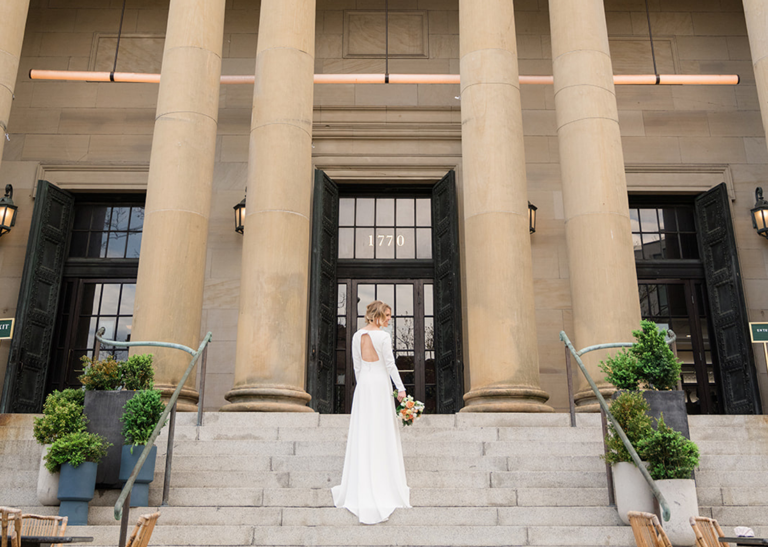 bride showing off her wedding dress as she faces away from the camera