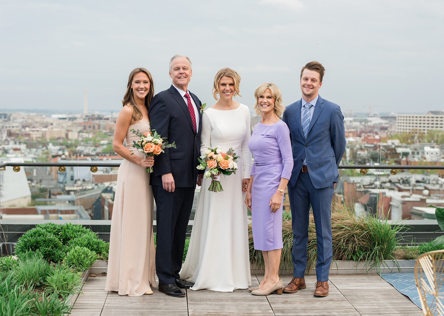 bride posing with her family on her wedding day on the rooftop of the Line hotel in Washington