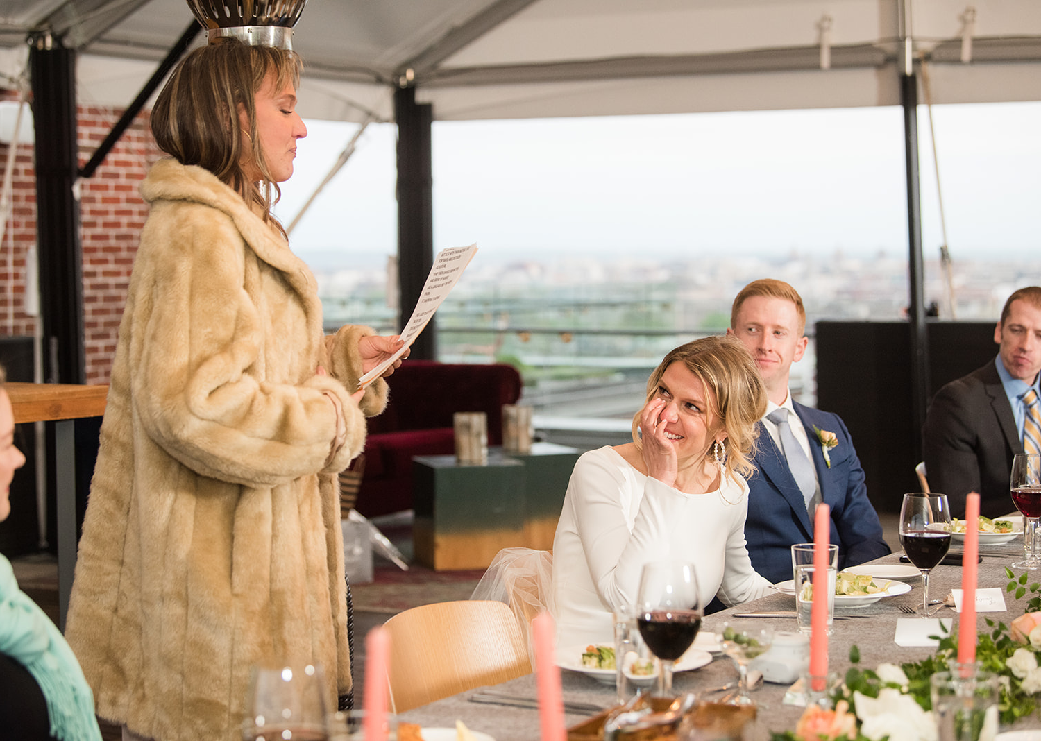 bride gets emotional as she looks at one of her family members sharing a speech during their wedding reception