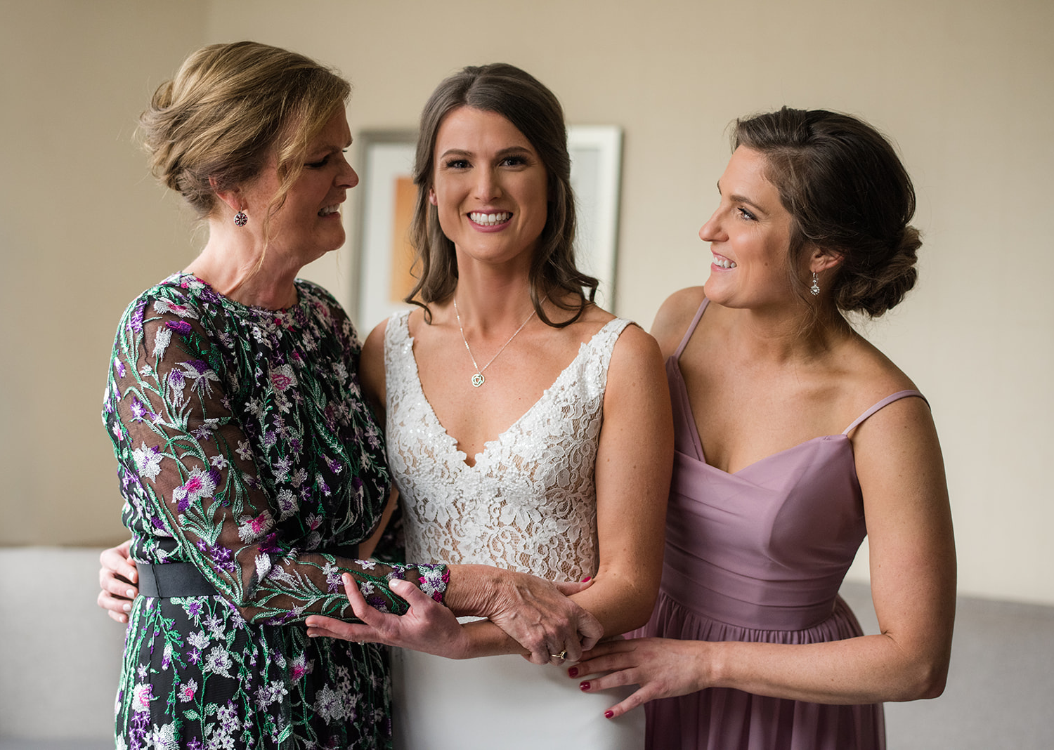 bride posing with her mother and bridesmaid