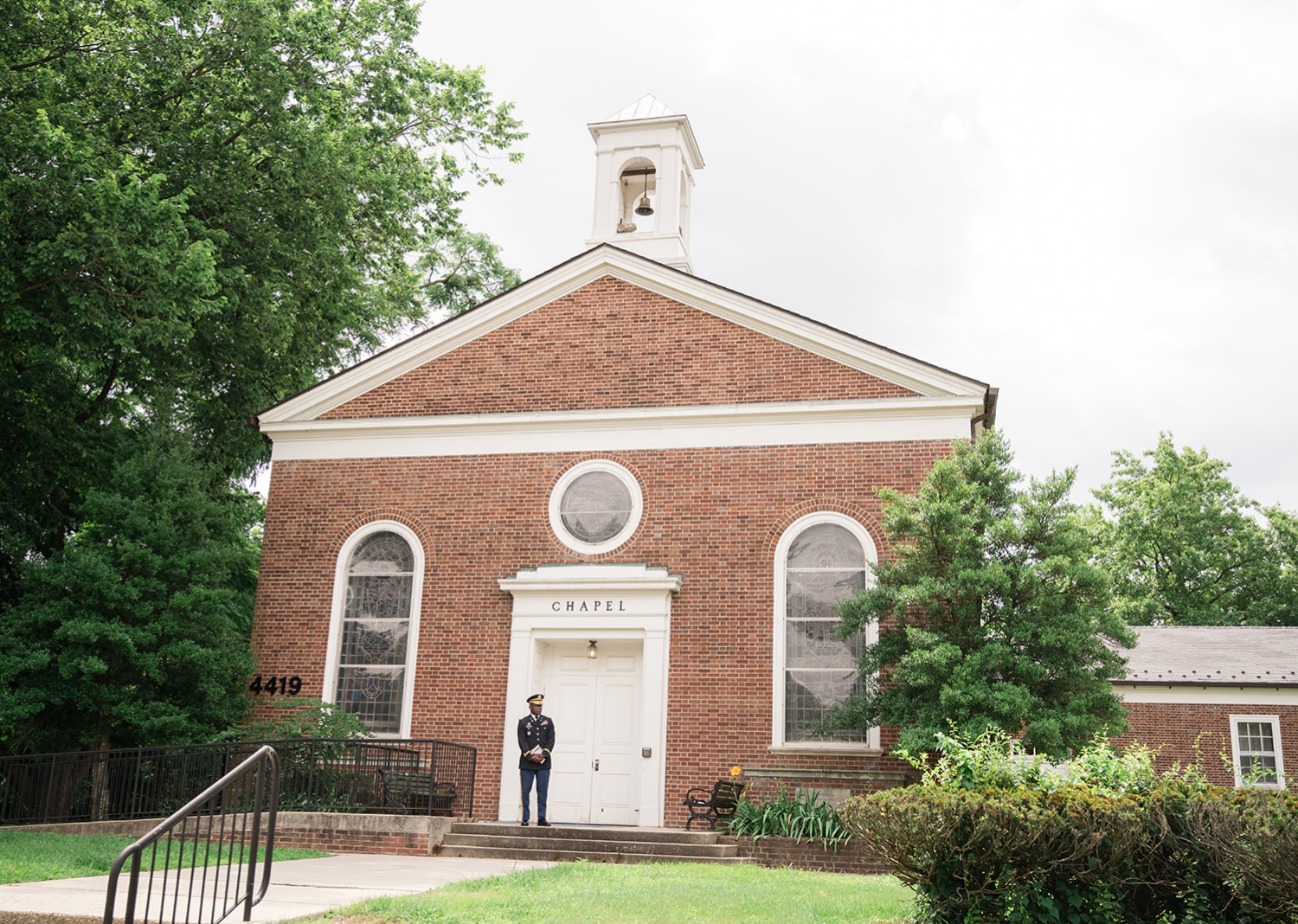 Reverend smiling in front of the chapel 