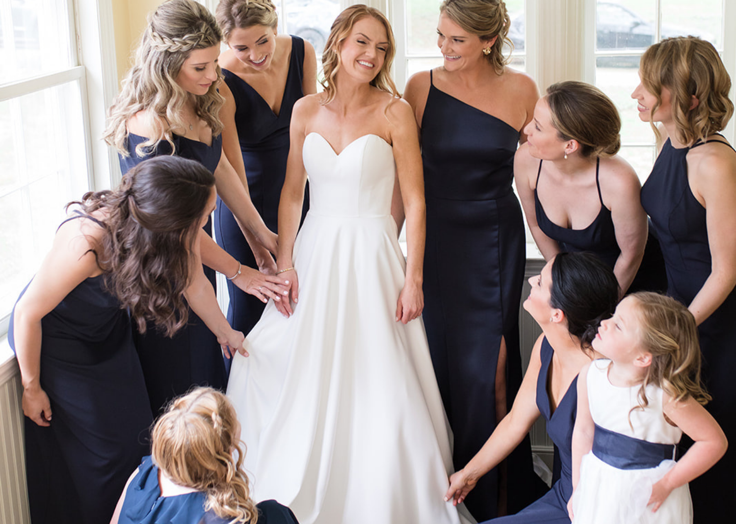 bridesmaids looking at the bride in her wedding dress 