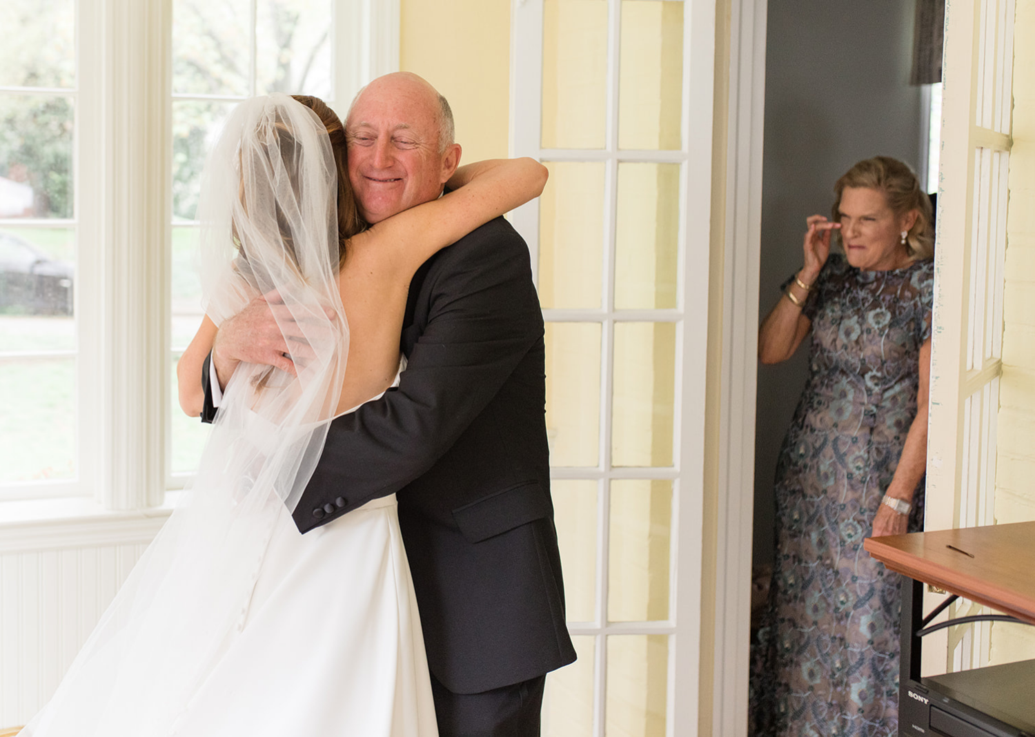 father of the bride and the bride share a hug 