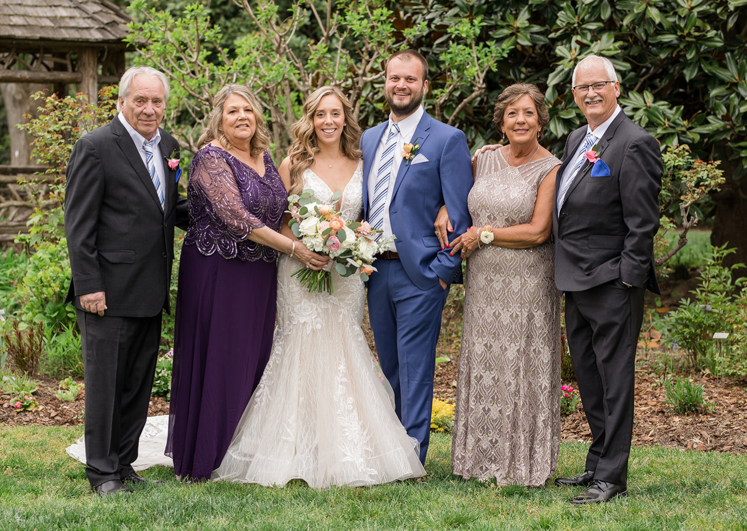 bride and groom with their families for outdoor wedding portraits