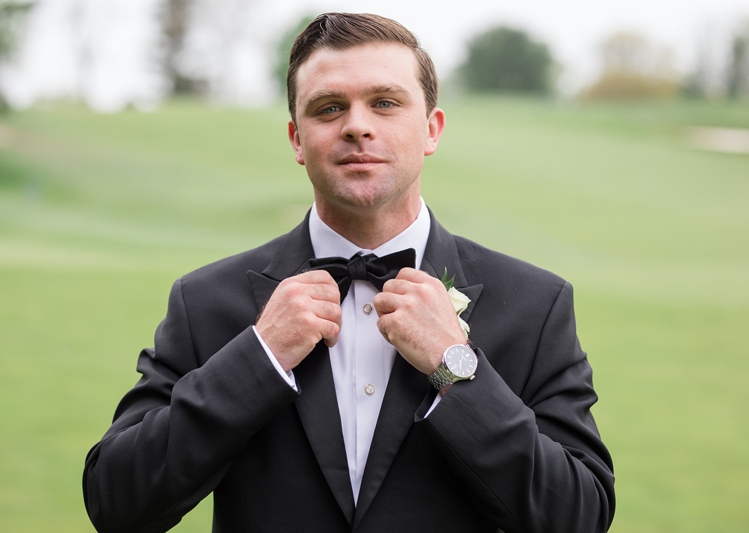 groom fixing his bow tie 