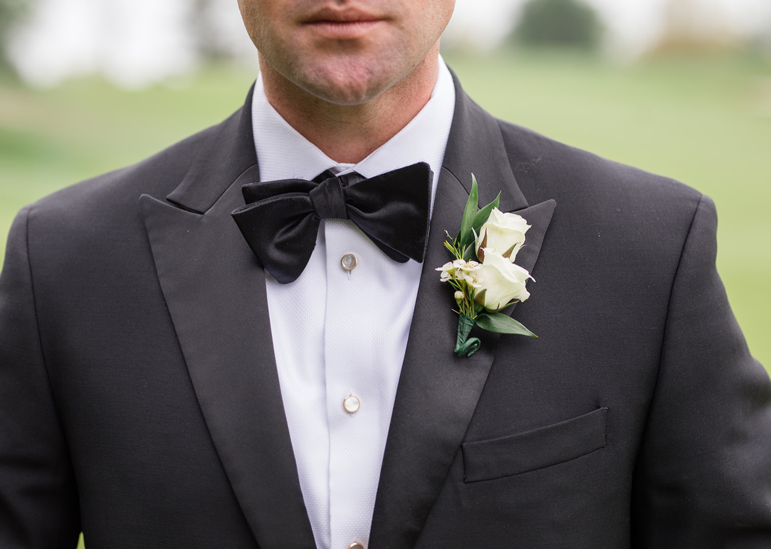 close up shot of the groom's bow tie and boutonniere 