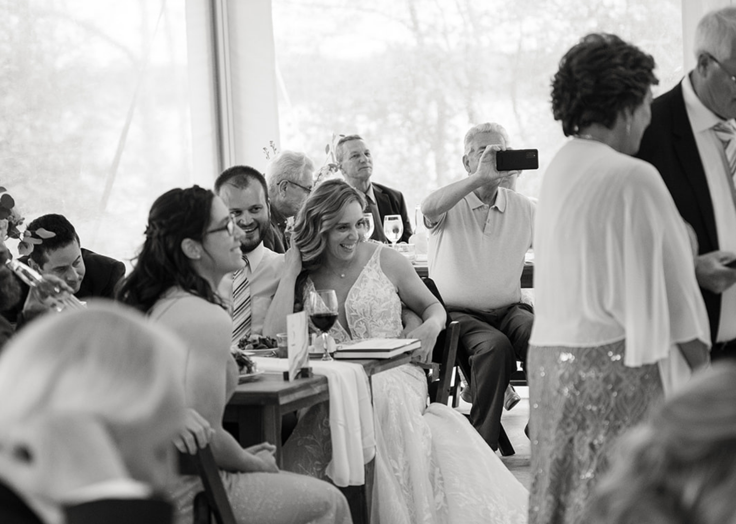 bride and groom smiling as they hear their wedding speeches