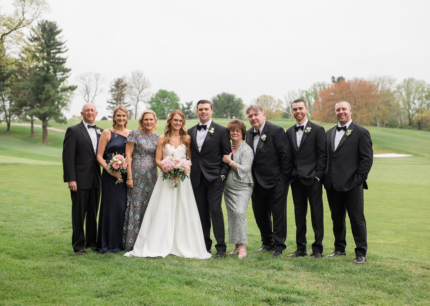 bride and groom with their family for family wedding portraits 