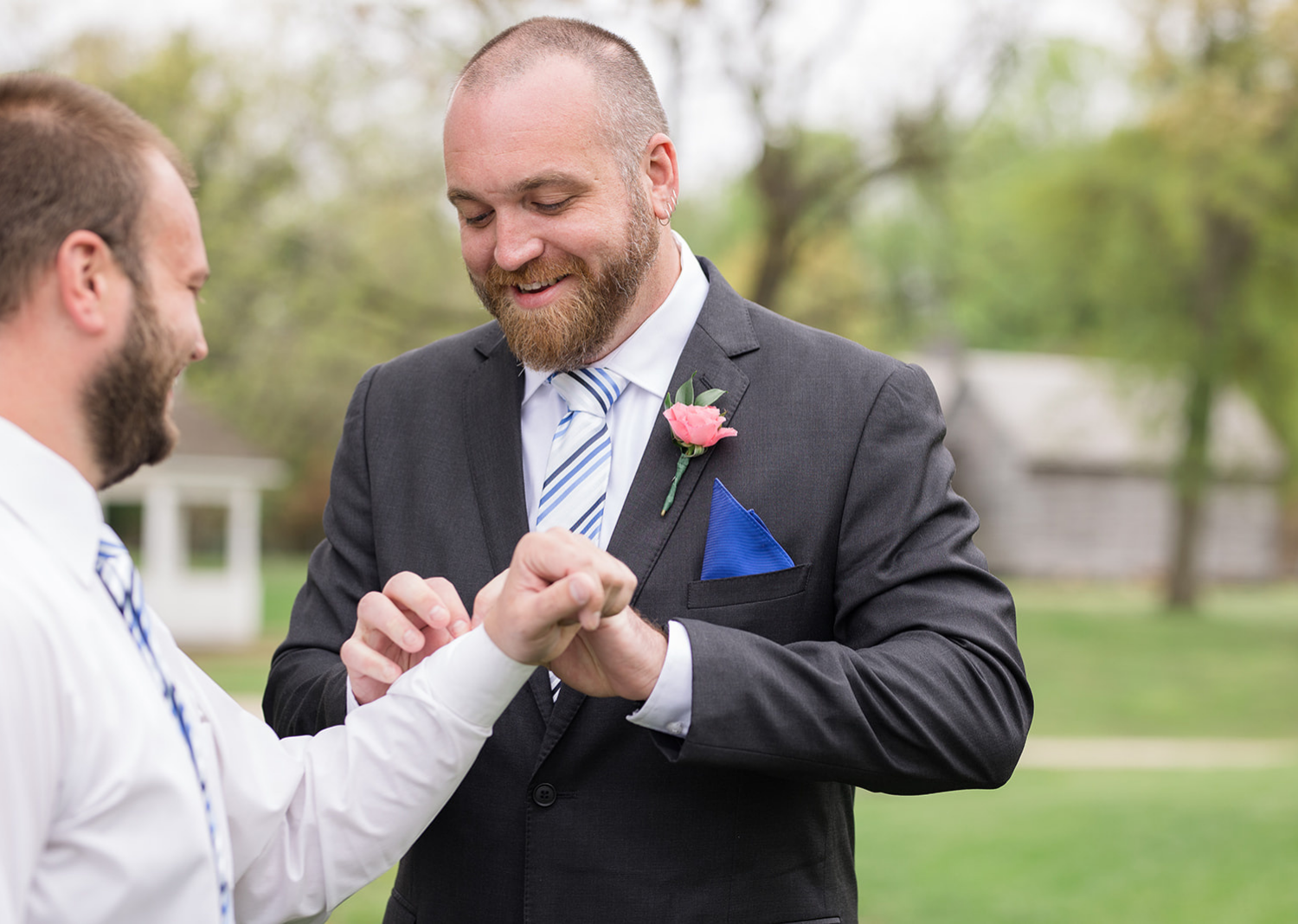 groomsmen helping groom with his cufflinks