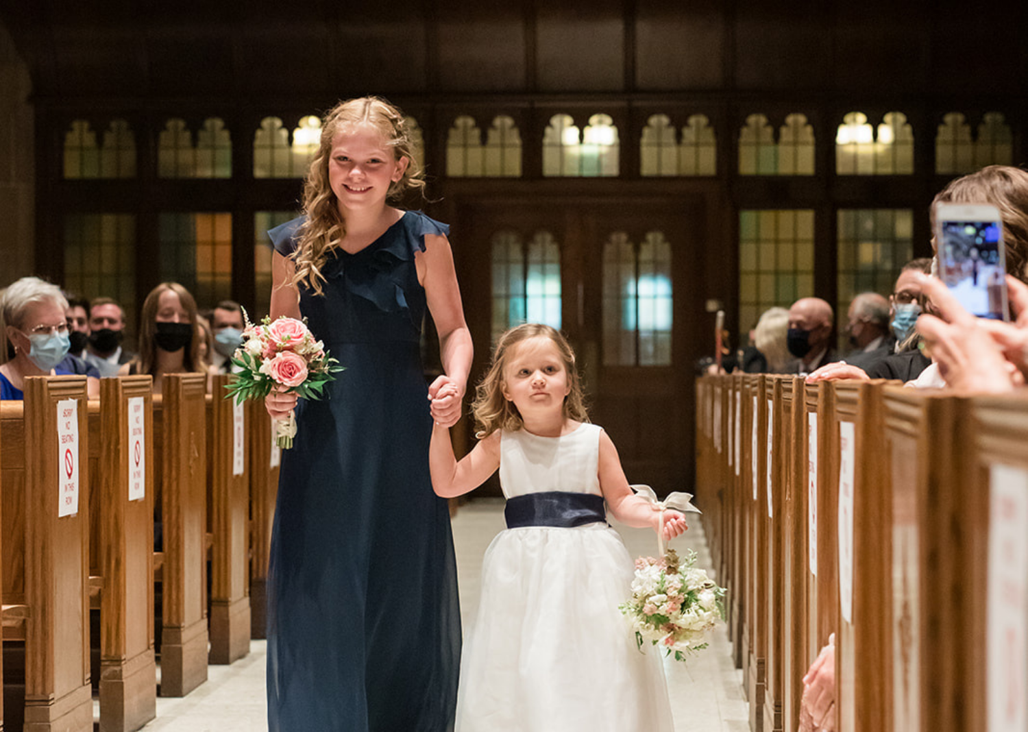 flower girls walking down the aisle of the wedding ceremony