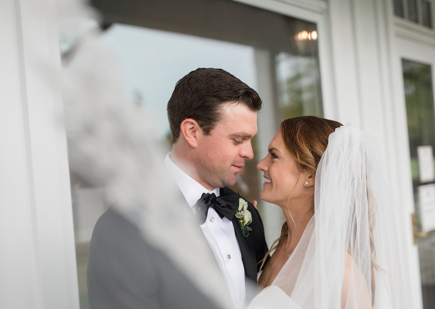 bride and groom wedding day portraits in front of the Elkridge country club 