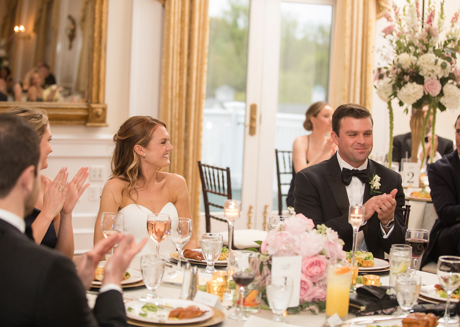 bride and groom clapping during the weddign reception