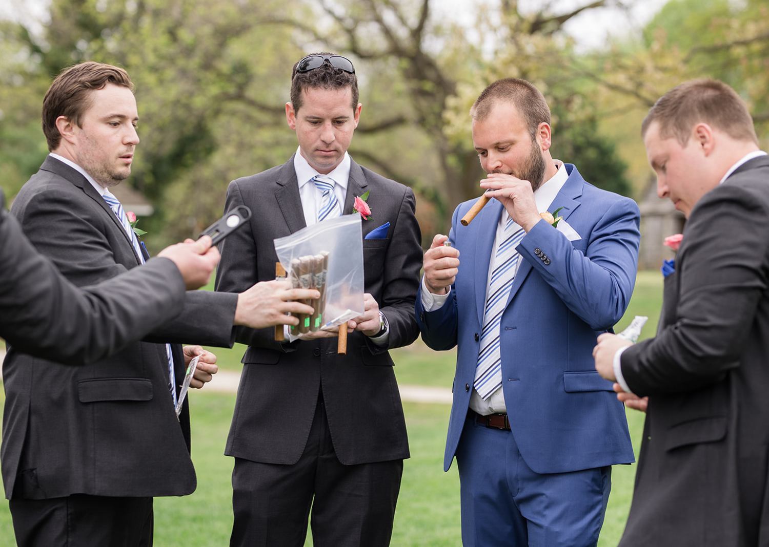 groom and groomsmen smoking cigars before the wedding 